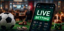 Smartphone showing a live betting screen next to a football